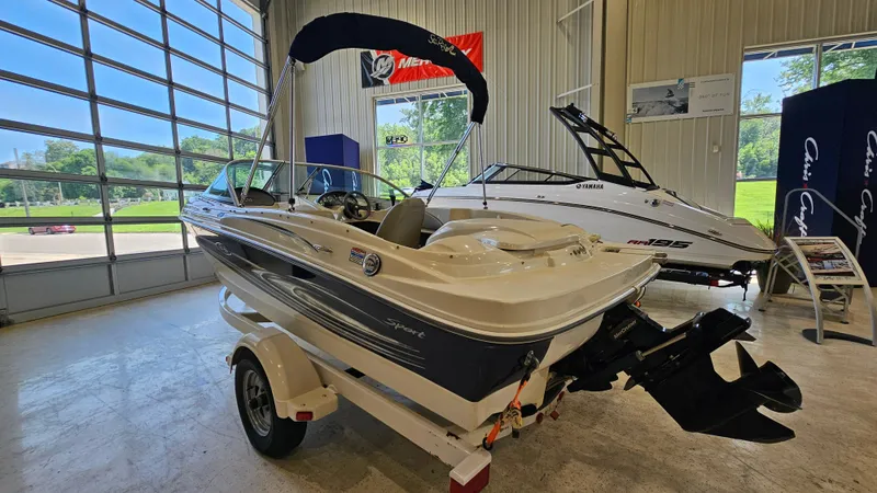 Slide: The Image of 2005 Sea Ray 180 Sport boat displayed indoors, with trailer and canopy. - 3