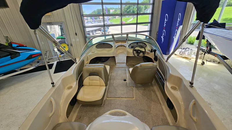 Slide: The Image of 2005 Sea Ray 180 Sport boat interior with seating and steering wheel in showroom. - 6