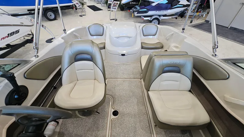 Slide: The Image of 2005 Sea Ray 180 Sport boat interior with beige seating and steering wheel. - 7