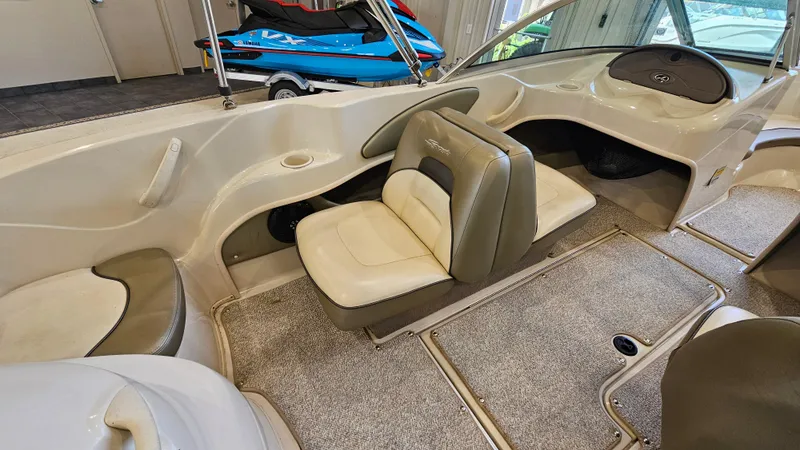 Slide: The Image of 2005 Sea Ray 180 Sport boat interior with beige seating and carpeted flooring. - 9