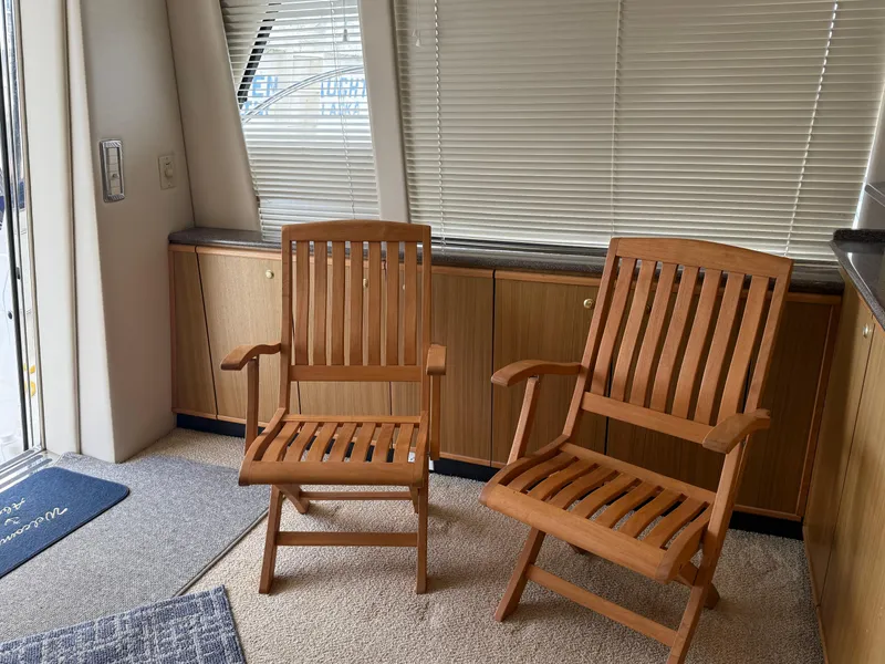 Slide: The Image of Interior of 2001 Bayliner 5288 Pilot House Motoryacht with wooden chairs and blinds. - 17