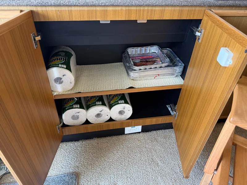 Slide: The Image of Open cabinet in 2001 Bayliner 5288 yacht with paper towels and foil trays. - 20