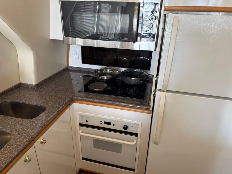 Slide: The Image of 2001 Bayliner 5288 Pilot House Motoryacht kitchen with stove, microwave, and refrigerator. - 26