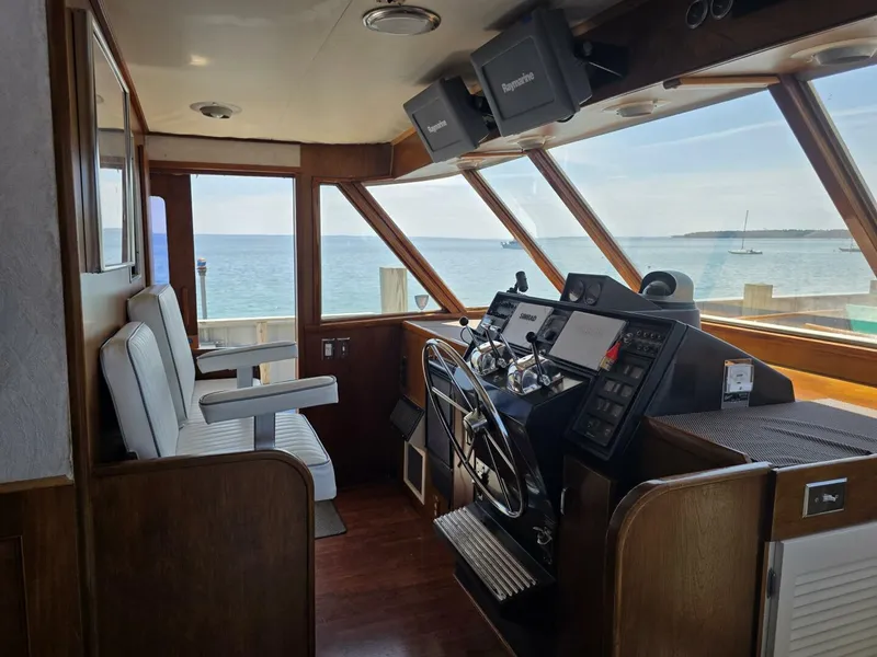 Slide: The Image of Helm of 1976 Chris-Craft Roamer 60 yacht with ocean view through large windows. - 10