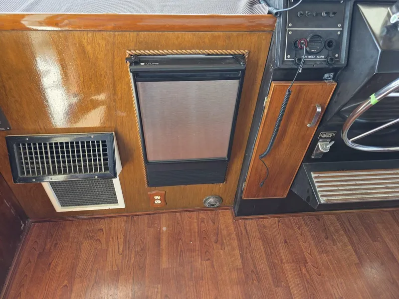 Slide: The Image of 1976 Chris-Craft Roamer 60 interior with wood paneling, fridge, and control panel. - 13