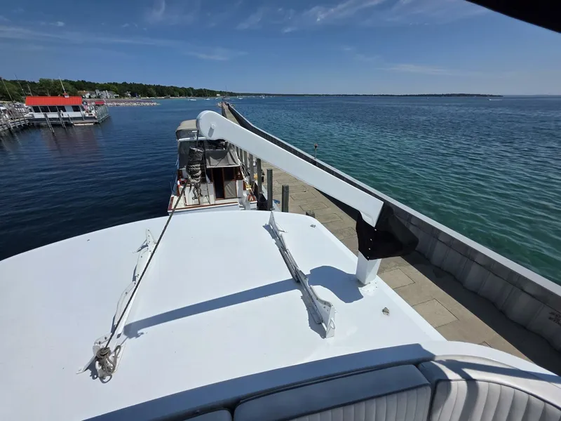 Slide: The Image of 1976 Chris-Craft Roamer 60 yacht docked by a scenic waterfront. - 23