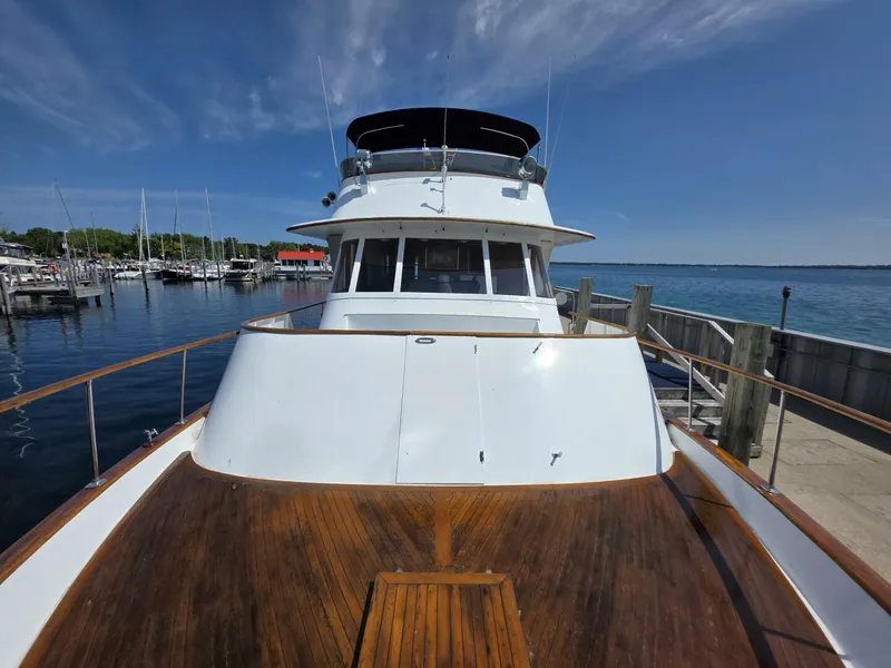 Slide: The Image of 1976 Chris-Craft Roamer 60 yacht docked at a marina under clear blue skies. - 9