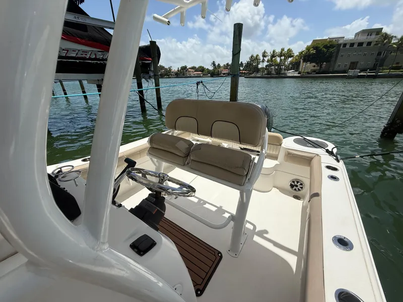 Slide: The Image of 2017 Sea Fox 226 Commander boat interior with steering wheel and seating, docked by the water. - 1