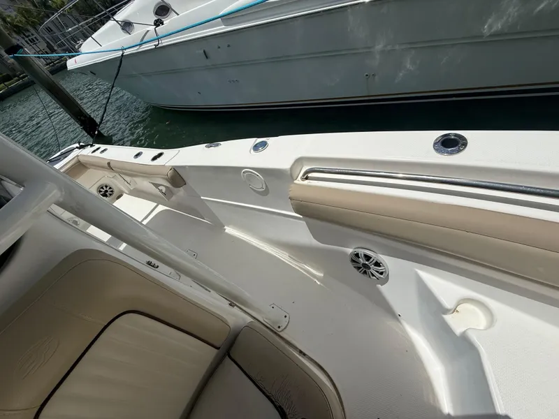 Slide: The Image of 2017 Sea Fox 226 Commander boat interior with seating and railing, docked beside another vessel. - 9
