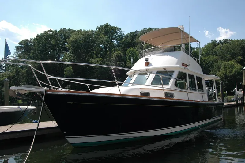 Slide: The Image of 2006 Sabre 36 Flybridge Sedan docked in a serene marina setting. - 0