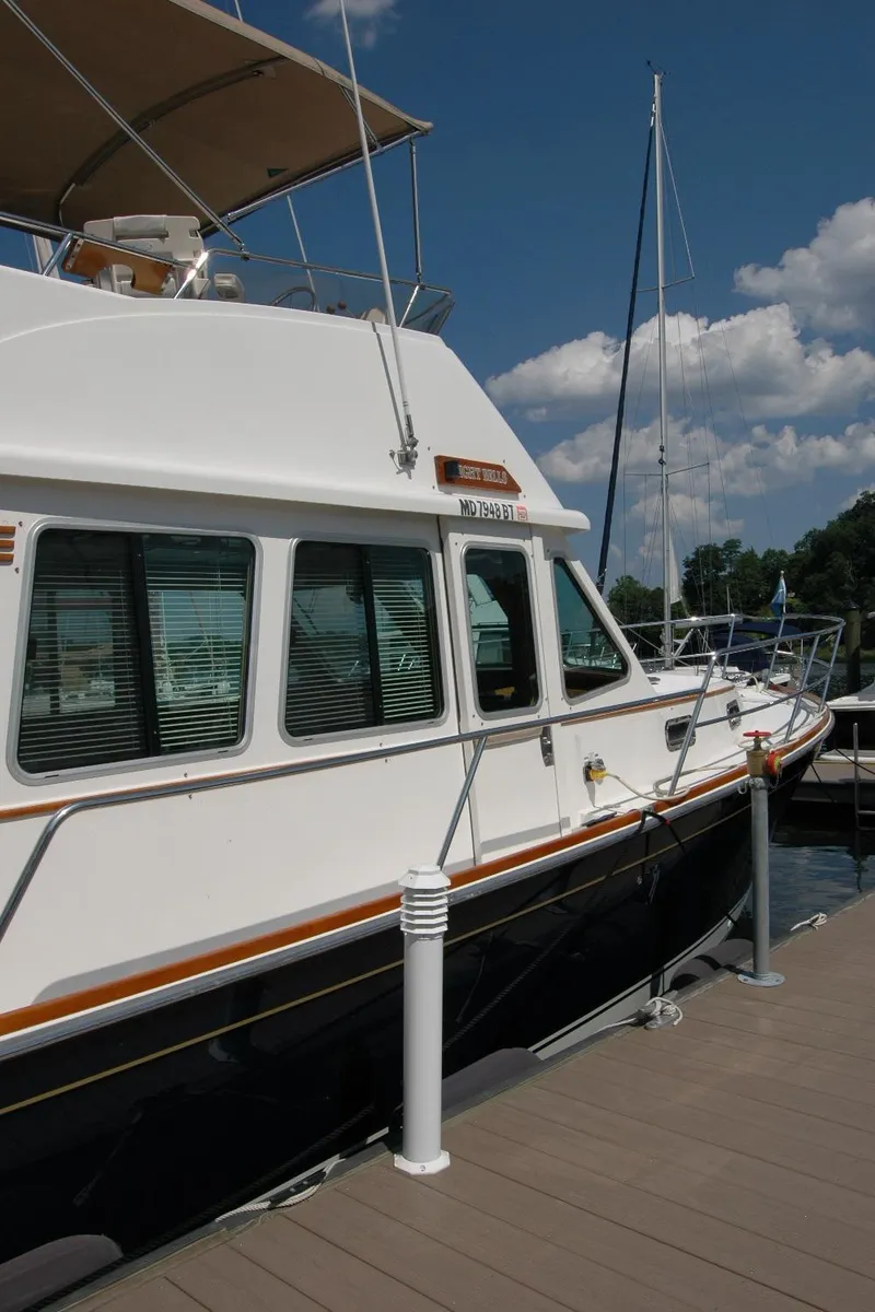 Slide: The Image of 2006 Sabre 36 Flybridge Sedan docked at marina under clear blue sky. - 11