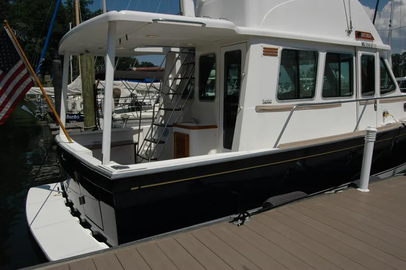 Slide: The Image of 2006 Sabre 36 Flybridge Sedan docked, featuring sleek design and American flag. - 14