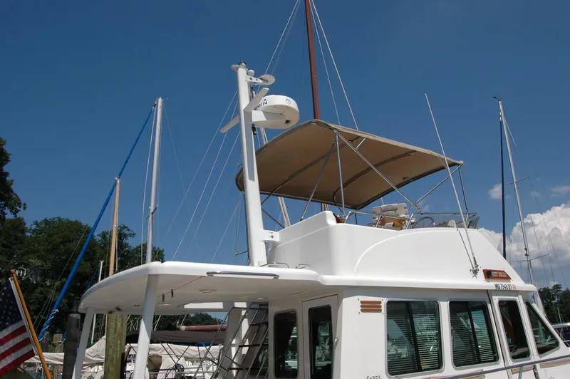 Slide: The Image of 2006 Sabre 36 Flybridge Sedan yacht with canopy, docked under clear blue sky. - 15