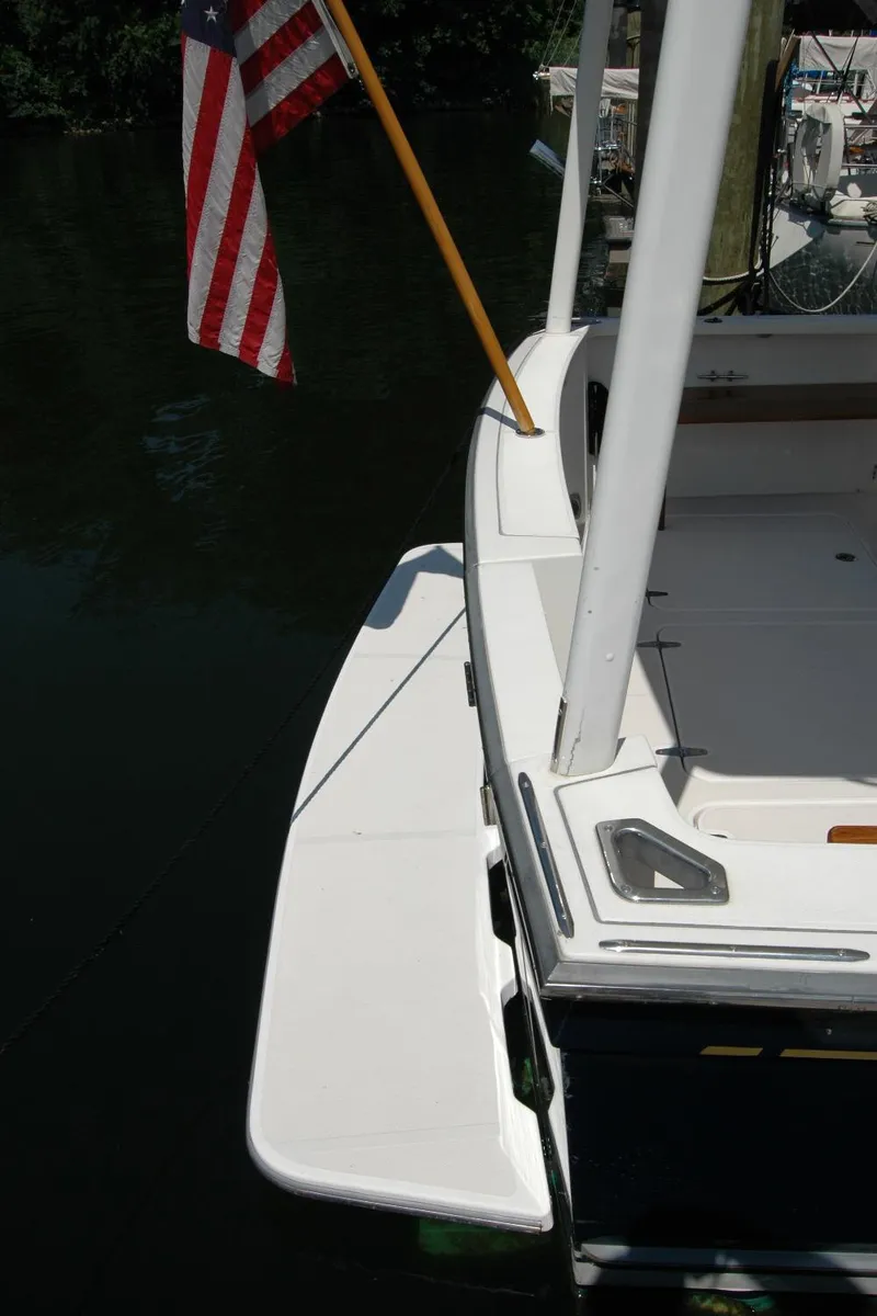 Slide: The Image of 2006 Sabre 36 Flybridge Sedan boat with American flag, docked on calm water. - 18