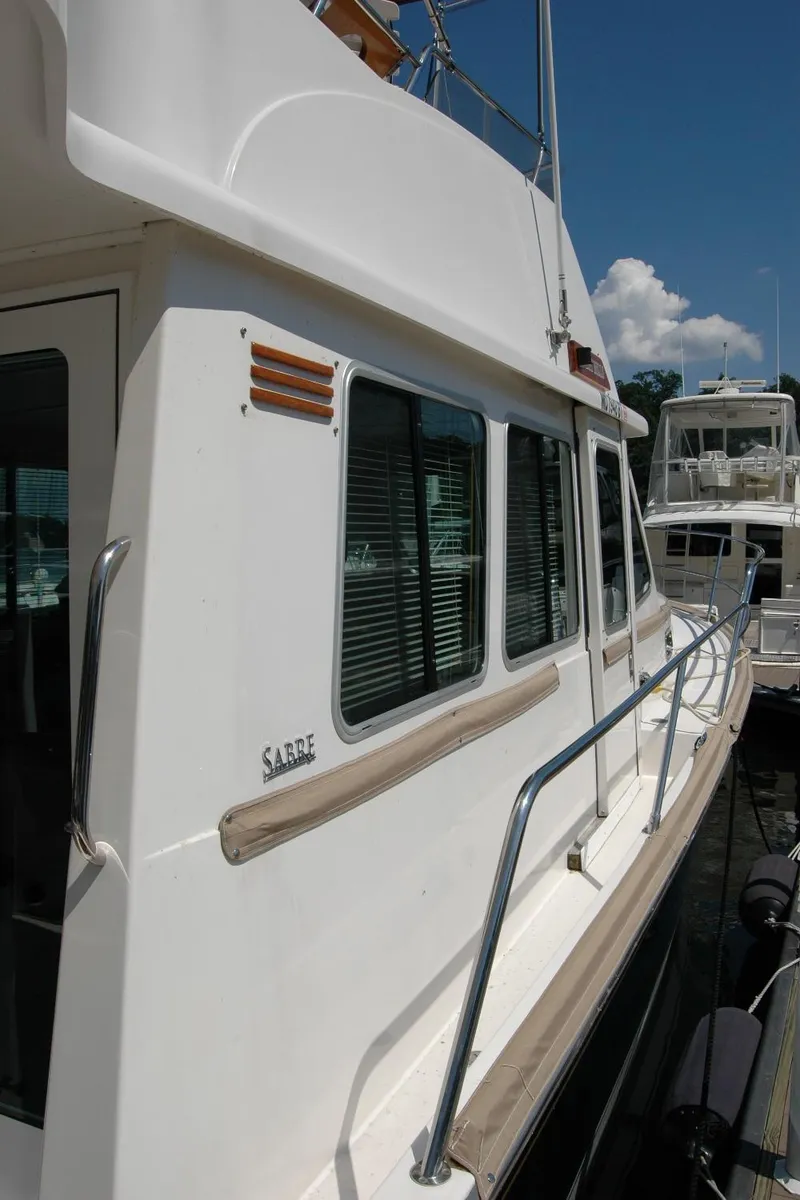 Slide: The Image of 2006 Sabre 36 Flybridge Sedan yacht docked, showcasing sleek design and windows. - 20