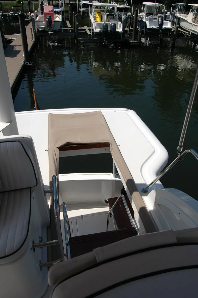 Slide: The Image of 2006 Sabre 36 Flybridge Sedan at marina, showcasing deck and seating area. - 33