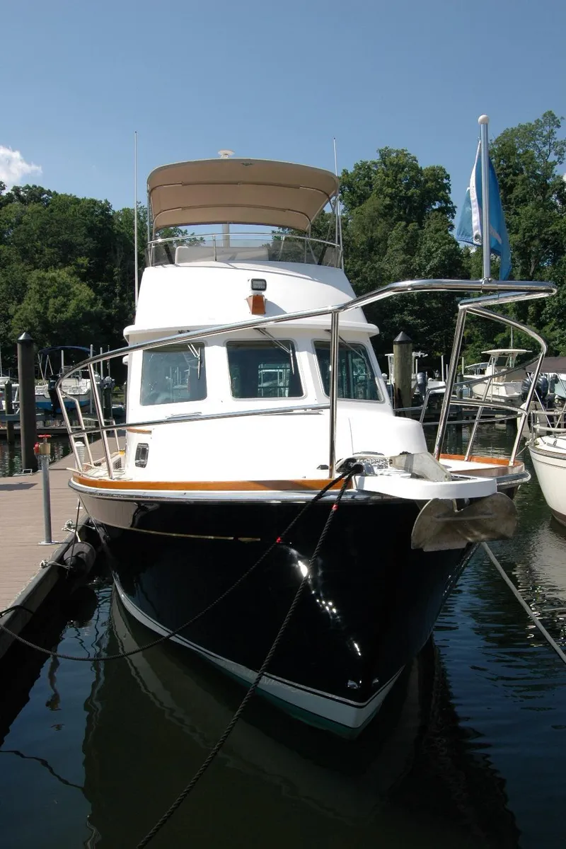 Slide: The Image of 2006 Sabre 36 Flybridge Sedan docked at marina, surrounded by trees and boats. - 4