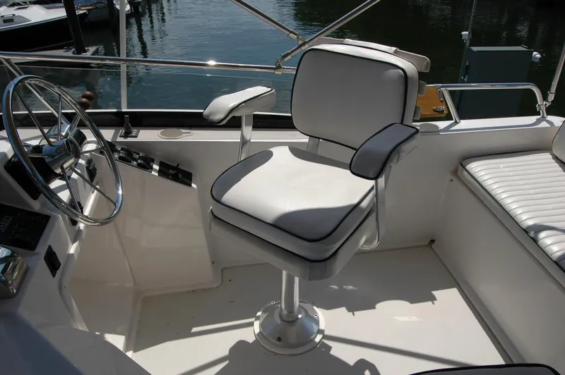 Slide: The Image of 2006 Sabre 36 Flybridge Sedan helm with white captain's chair and steering wheel. - 42