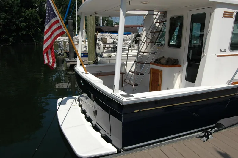 Slide: The Image of 2006 Sabre 36 Flybridge Sedan docked, featuring American flag and sleek design. - 7