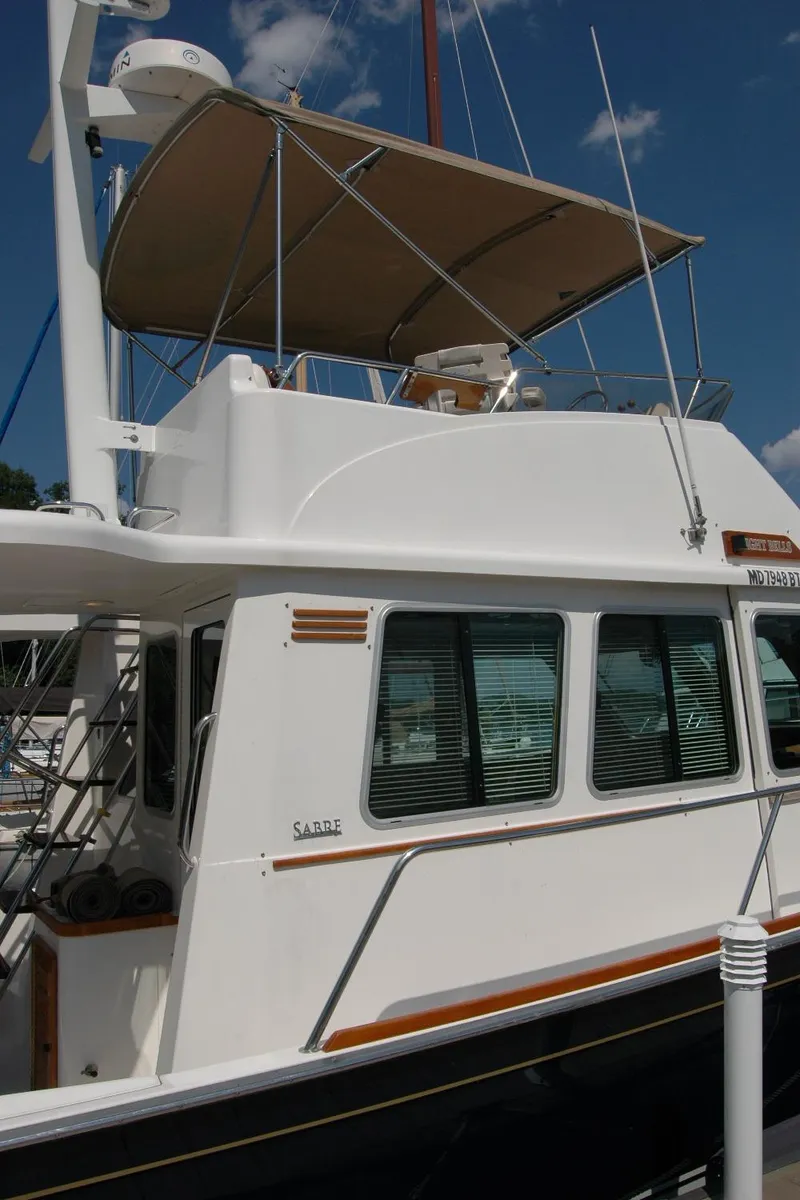 Slide: The Image of 2006 Sabre 36 Flybridge Sedan yacht with canopy, docked under a clear blue sky. - 8