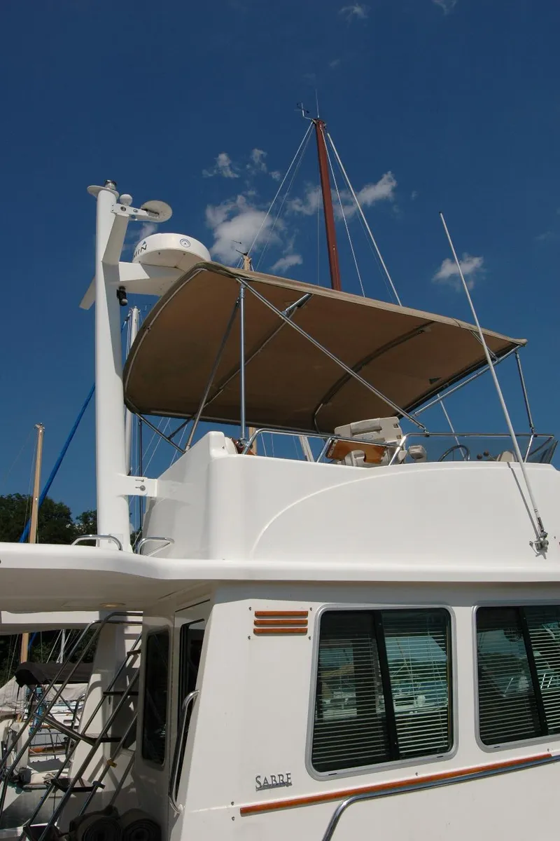 Slide: The Image of 2006 Sabre 36 Flybridge Sedan with canopy, docked under clear blue sky. - 9