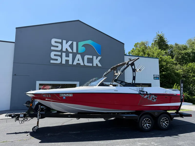 Slide: The Image of Red 2011 Axis A22 boat on trailer outside Ski Shack building. - 0