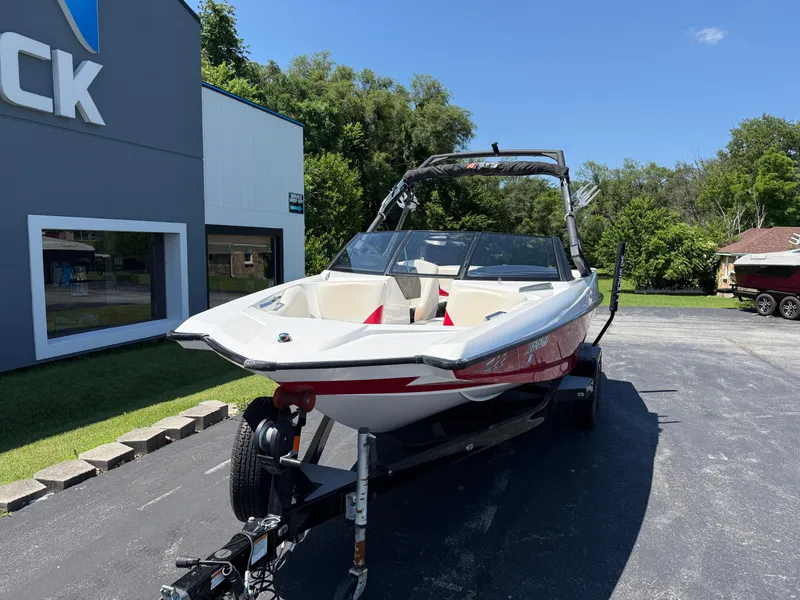 Slide: The Image of 2011 Axis A22 boat on trailer, parked outside dealership on sunny day. - 1