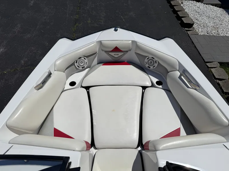 Slide: The Image of 2011 Axis A22 boat interior with white and red cushioned seating and built-in speakers. - 11