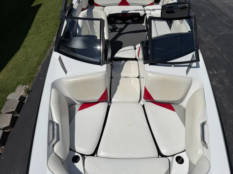 Slide: The Image of 2011 Axis A22 boat interior with white and red seating, open windshield, and spacious layout. - 12