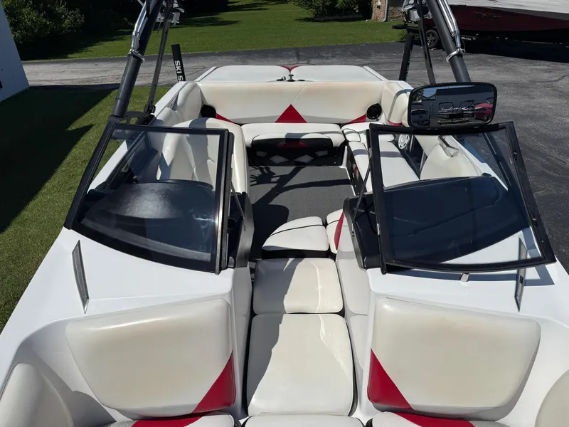 Slide: The Image of 2011 Axis A22 boat interior with white and red seating, open windshield, and tower. - 13
