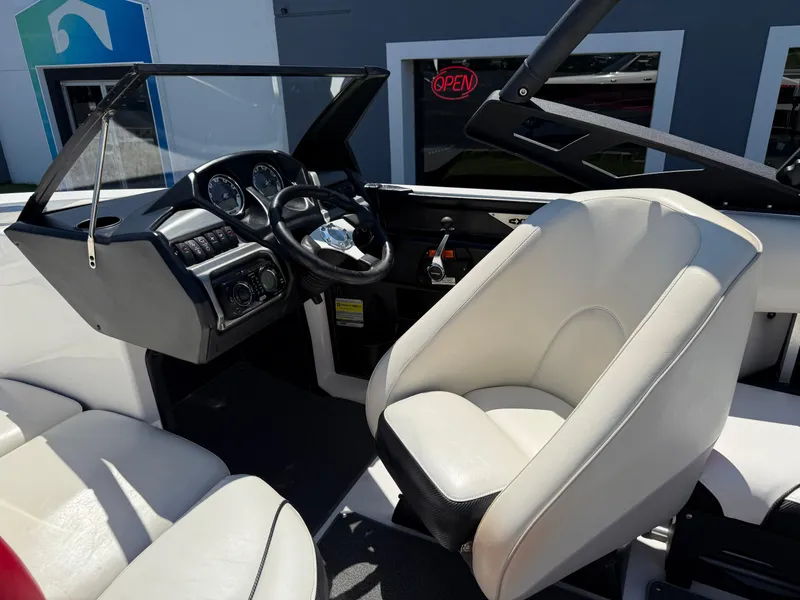 Slide: The Image of 2011 Axis A22 boat interior with steering wheel and white seating. - 16
