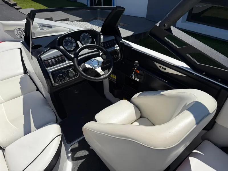Slide: The Image of 2011 Axis A22 boat interior with steering wheel and white seating. - 19