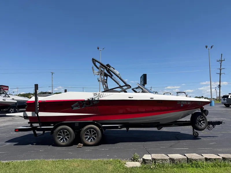 Slide: The Image of 2011 Axis A22 boat in red and white on a trailer under a clear blue sky. - 3