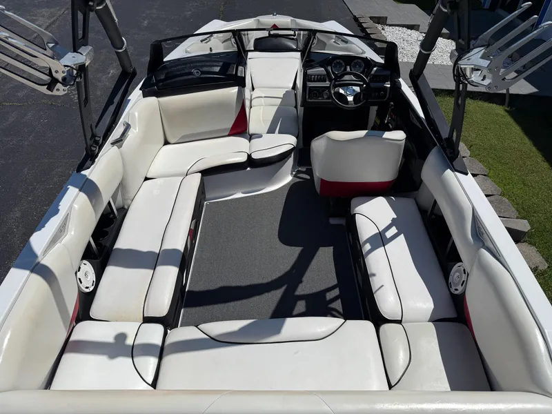 Slide: The Image of 2011 Axis A22 boat interior with white seating and modern dashboard. - 9