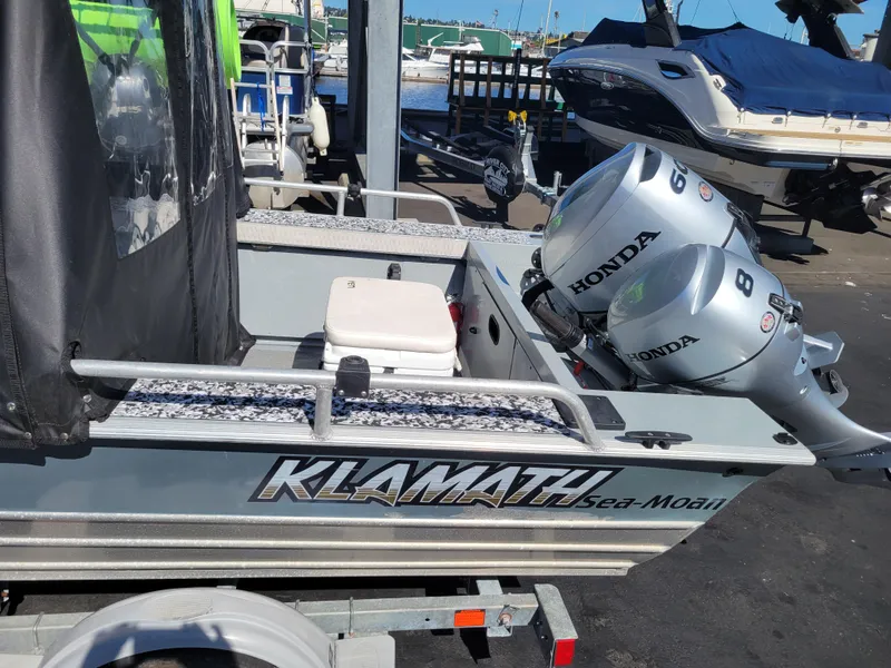 Slide: The Image of 2018 Klamath 18 OPW boat with dual Honda outboard motors at a marina. - 12