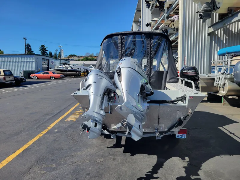 Slide: The Image of 2018 Klamath 18 OPW boat with dual outboard motors in a marina parking lot. - 4