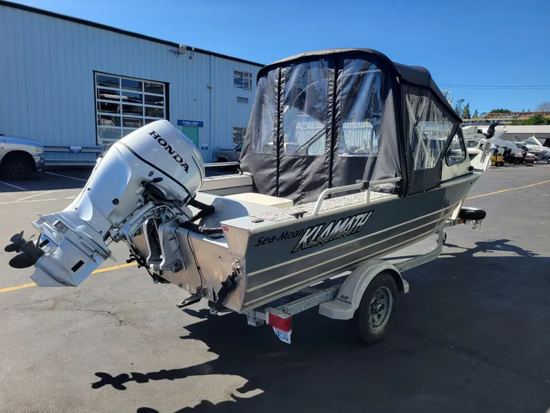 Slide: The Image of 2018 Klamath 18 OPW boat with Honda outboard motor in a parking lot. - 5