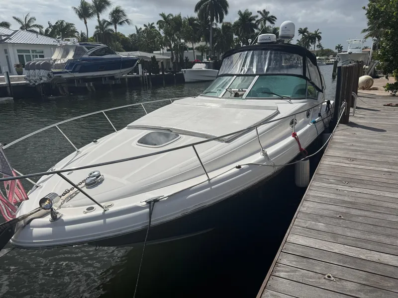 The Image of 2005 Sea Ray 340 Sundancer docked by palm trees and waterfront homes. - 0