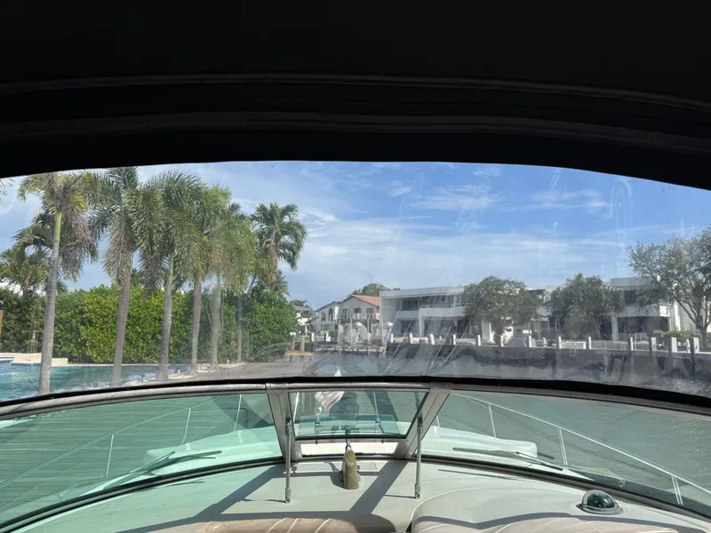 Slide: The Image of 2005 Sea Ray 340 Sundancer cruising near waterfront homes and palm trees. - 15