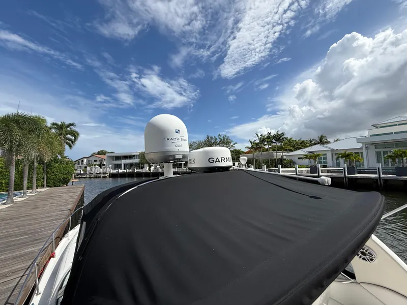 Slide: The Image of 2005 Sea Ray 340 Sundancer docked, featuring Garmin and TracVision equipment under a partly cloudy sky. - 18