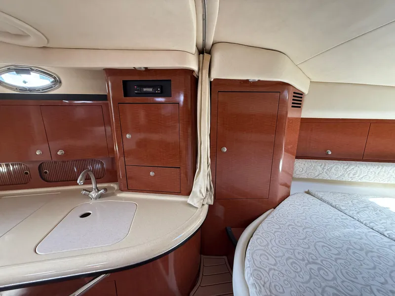 Slide: The Image of 2005 Sea Ray 340 Sundancer interior with wood cabinetry and cozy sleeping area. - 26
