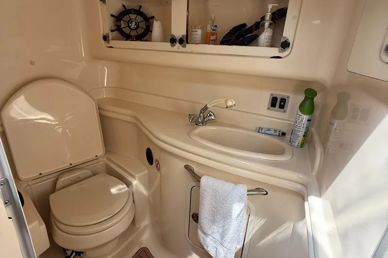 Slide: The Image of 2005 Sea Ray 340 Sundancer bathroom with sink, toilet, and storage shelves. - 28