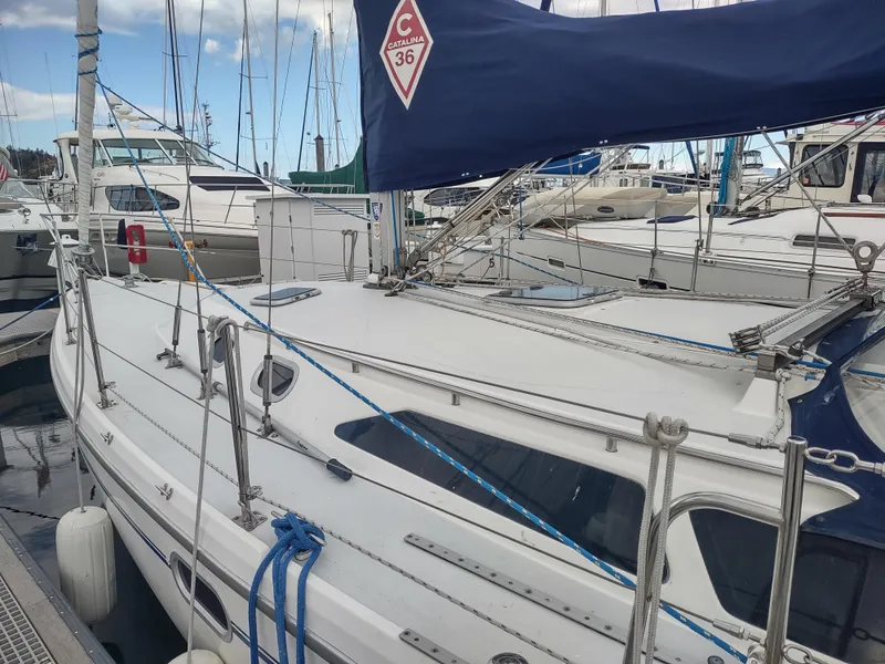 Slide: The Image of 2002 Catalina 36 MkII sailboat docked at marina, featuring sleek design and blue sail cover. - 10