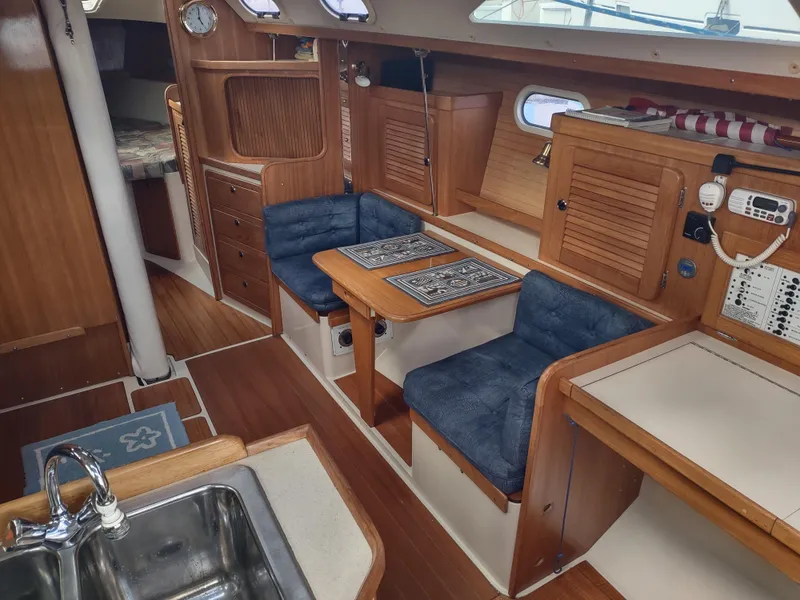 Slide: The Image of Interior of 2002 Catalina 36 MkII sailboat with wood finish and blue cushioned seating. - 26