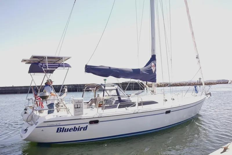 Slide: The Image of 2002 Catalina 36 MkII sailboat "Bluebird" on water with solar panels and American flag. - 3