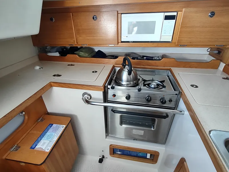 Slide: The Image of Galley kitchen in 2002 Catalina 36 MkII sailboat with stove, microwave, and wooden cabinetry. - 31