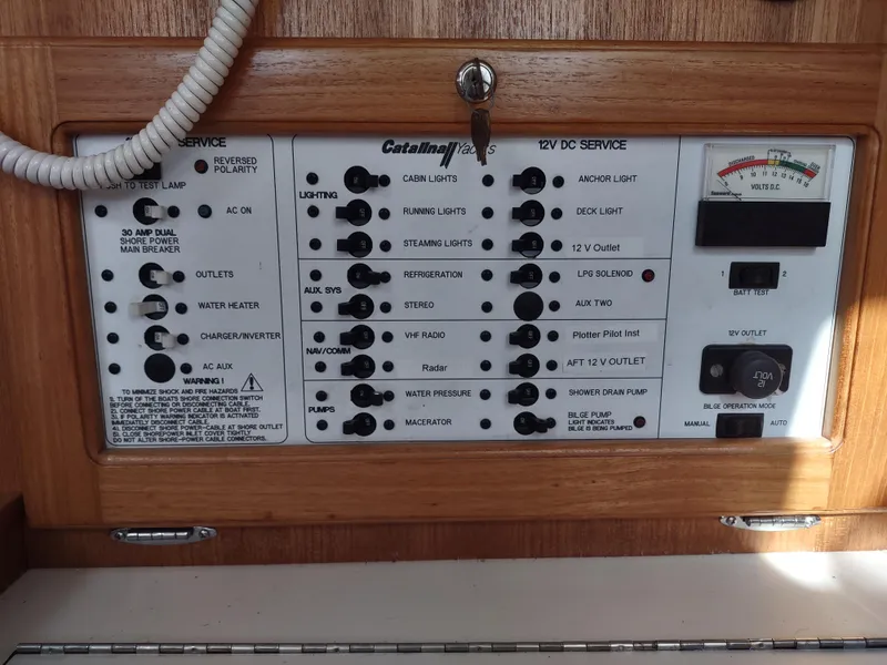 Slide: The Image of Control panel of a 2002 Catalina 36 MkII yacht, featuring various switches and gauges. - 39