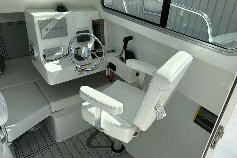 Slide: The Image of Interior of 2026 Parker 2220 SC boat with Garmin navigation system and white captain's chair. - 14