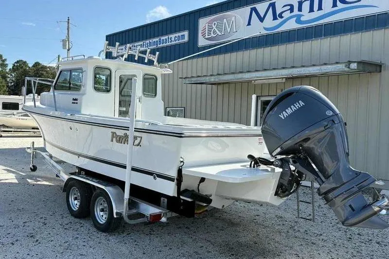 Slide: The Image of 2026 Parker 2220 SC boat with Yamaha engine on trailer at marina. - 2