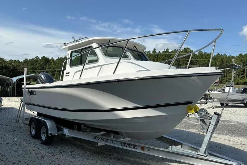 Slide: The Image of 2026 Parker 2220 SC boat on trailer, parked outdoors under clear sky. - 6